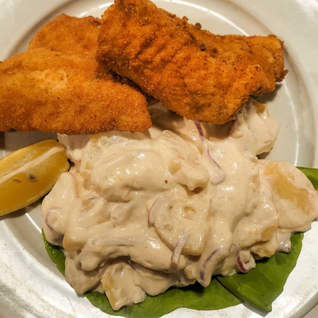 Plate of fried fish with potato salad