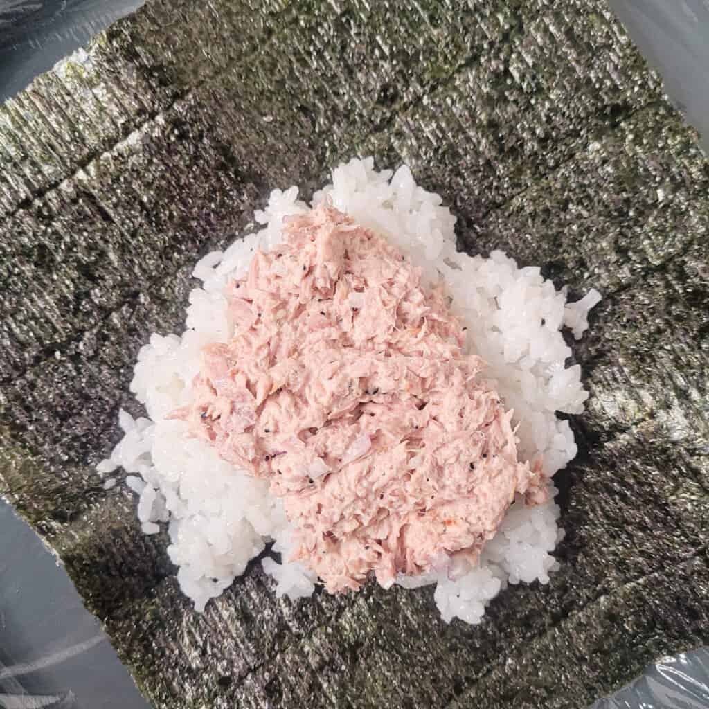Tuna on top of rice on a sheet of seaweed