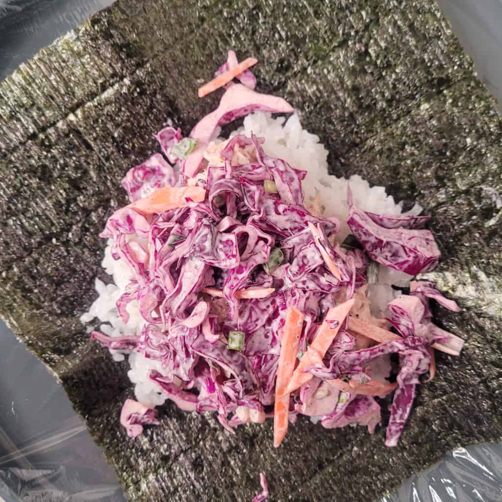 Vegetables on top of rice on sheet of seaweed