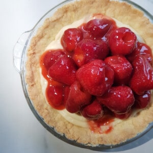 Place glazed strawberries on top of the custard in the pie.