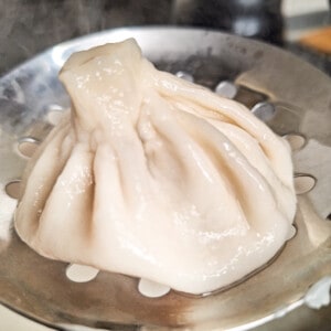 A piece of meat khinkali on a strainer.