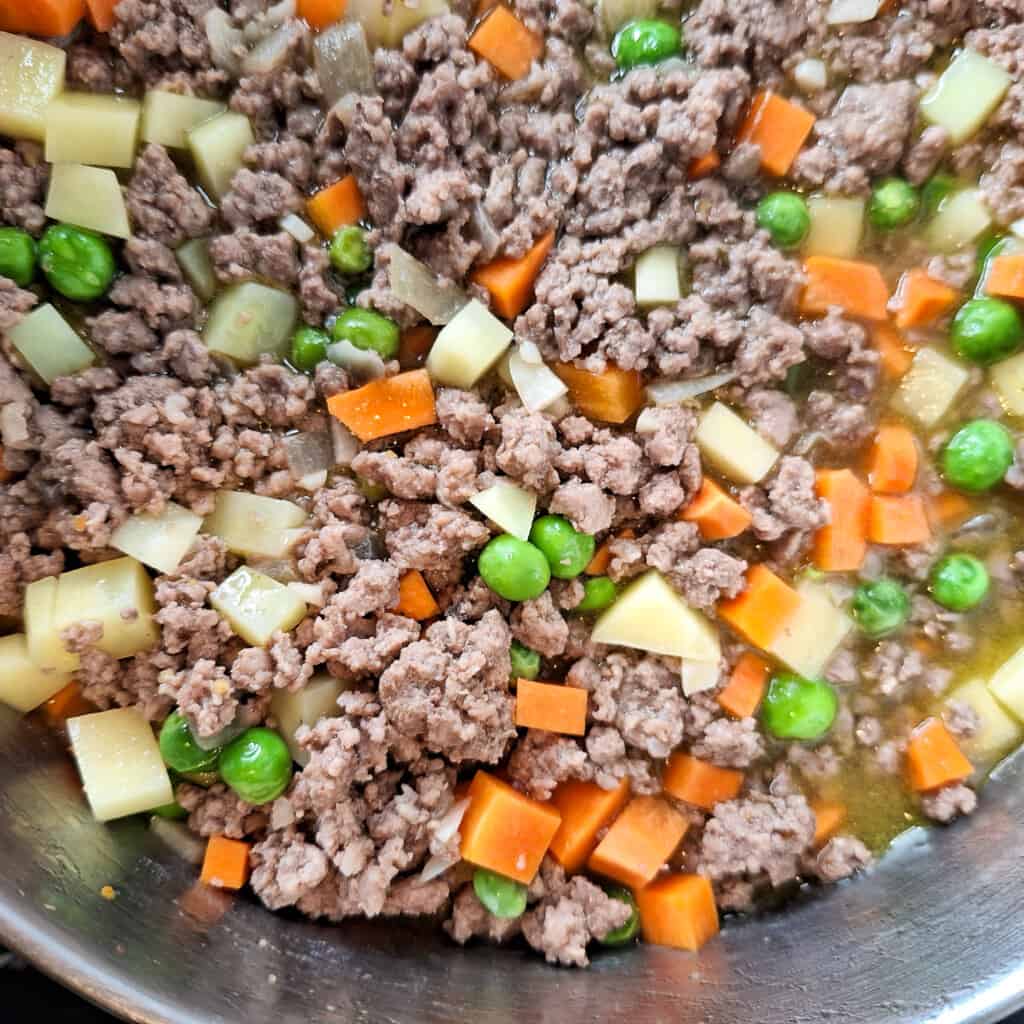 Beef and pork giniling in a pot with some broth