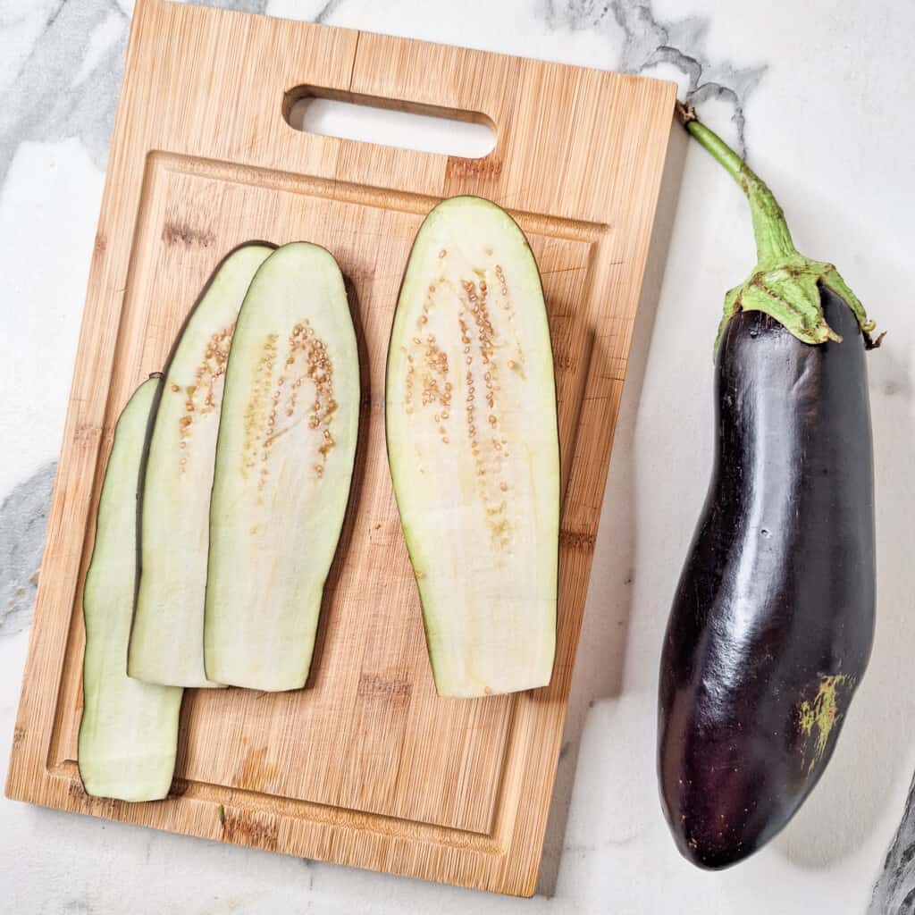 Sliced strips of eggplant on a cutting board