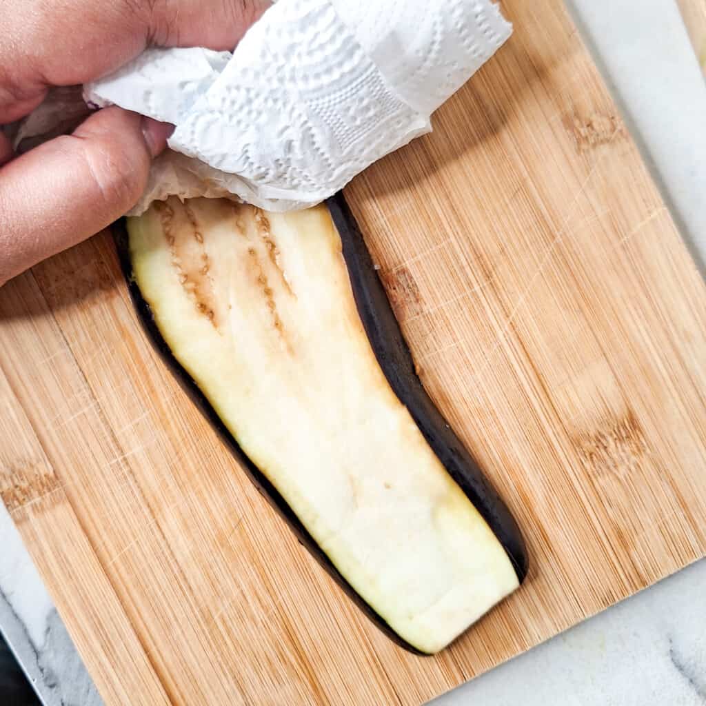 Wipe the eggplant slice with a paper towel
