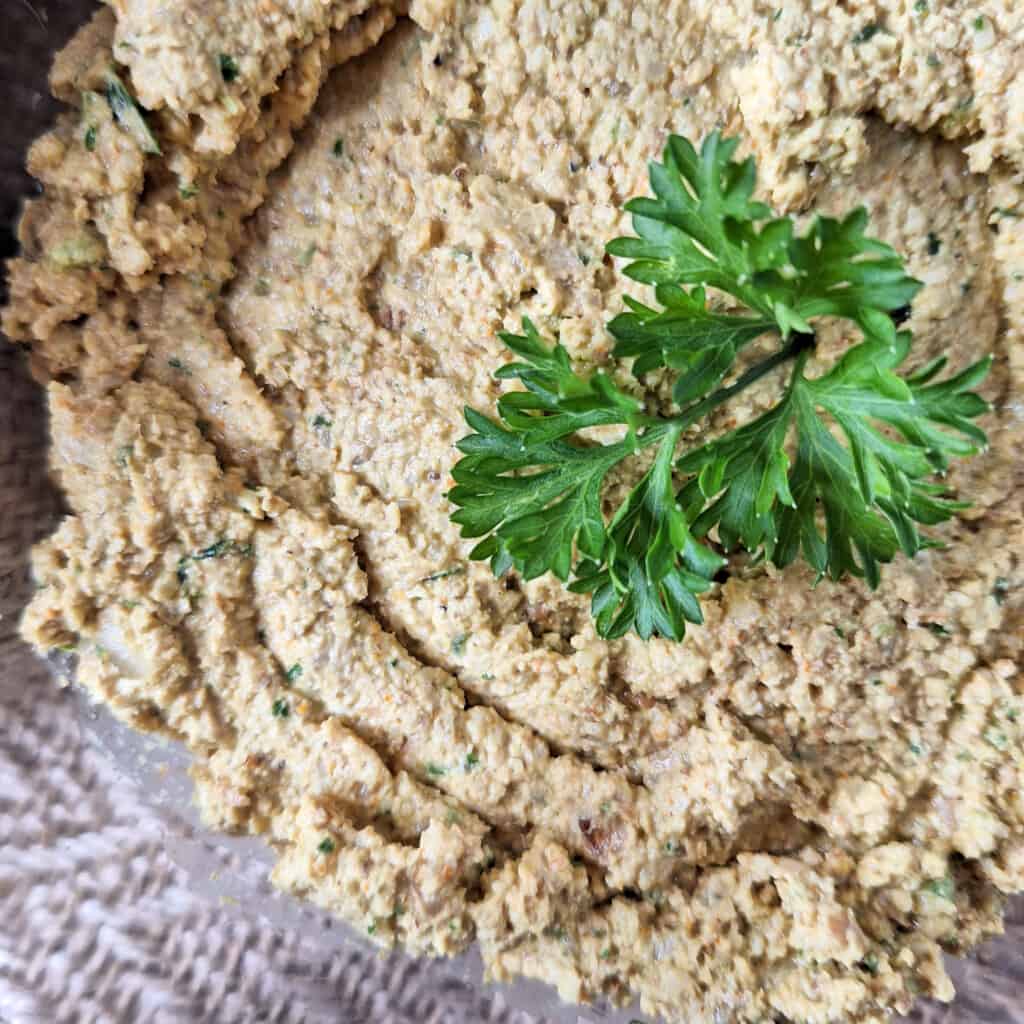 close up of walnut paste with a piece of parsley