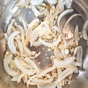 A stockpot with oil, onions, and garlic
