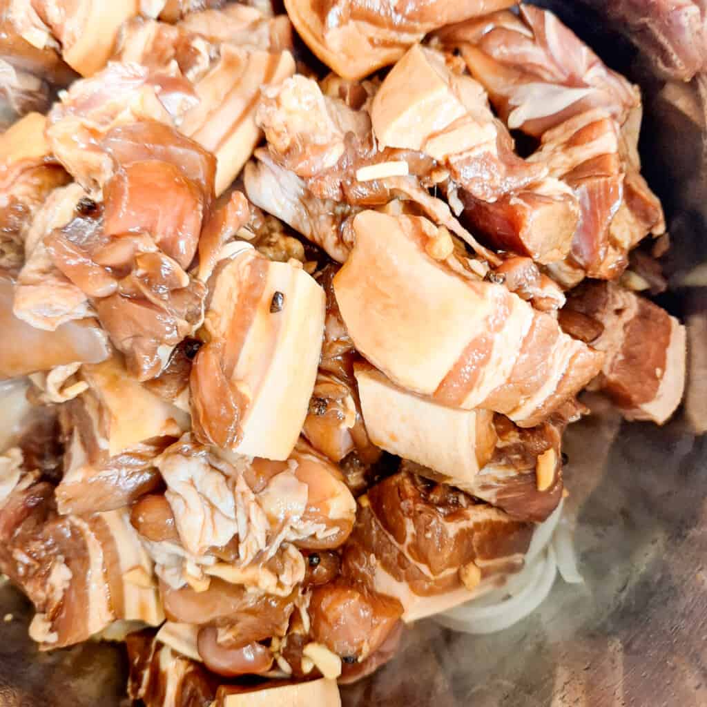 Raw meat pieces such as pork inside a stockpot