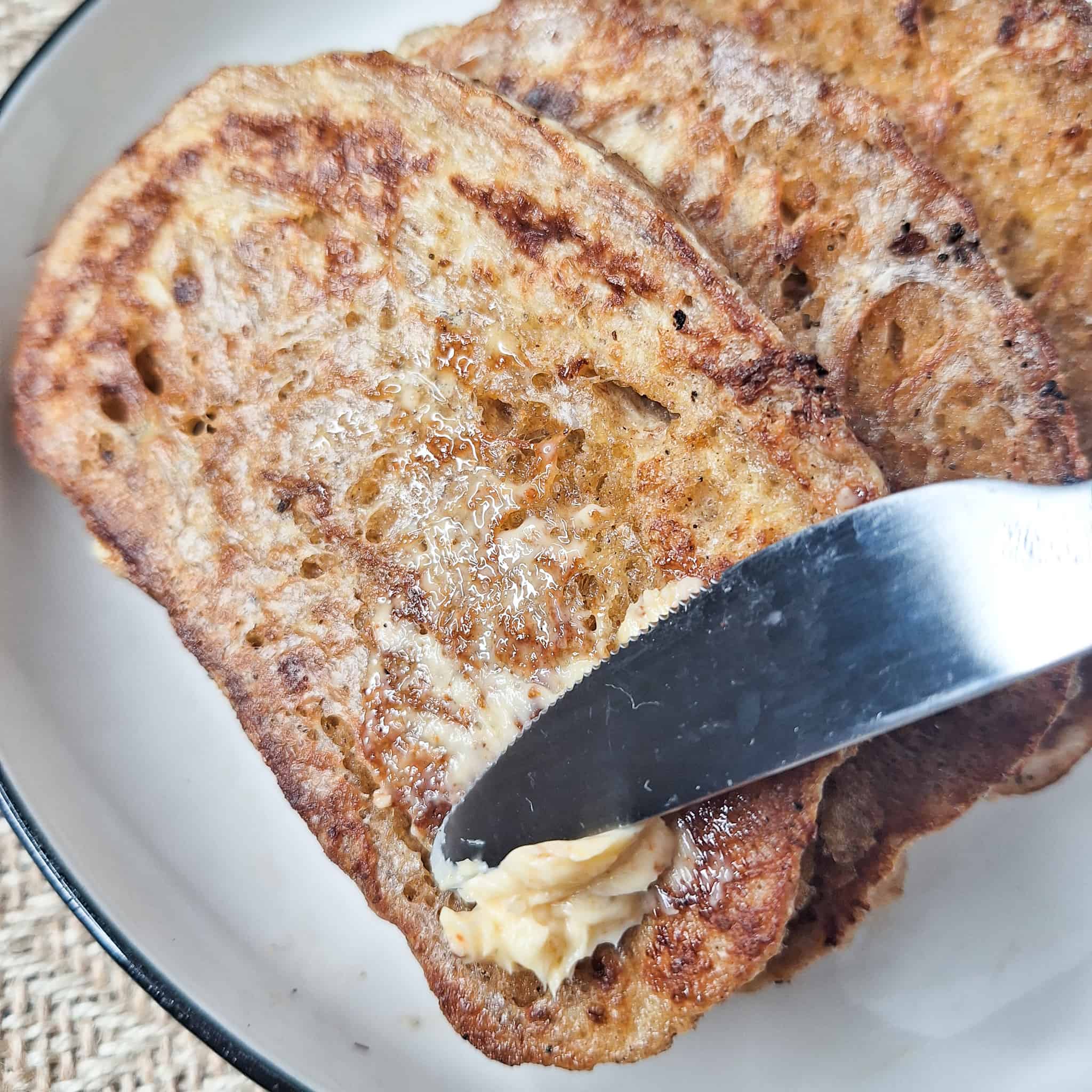 Adding melted adjika butter on Georgian egg bread or kikliko