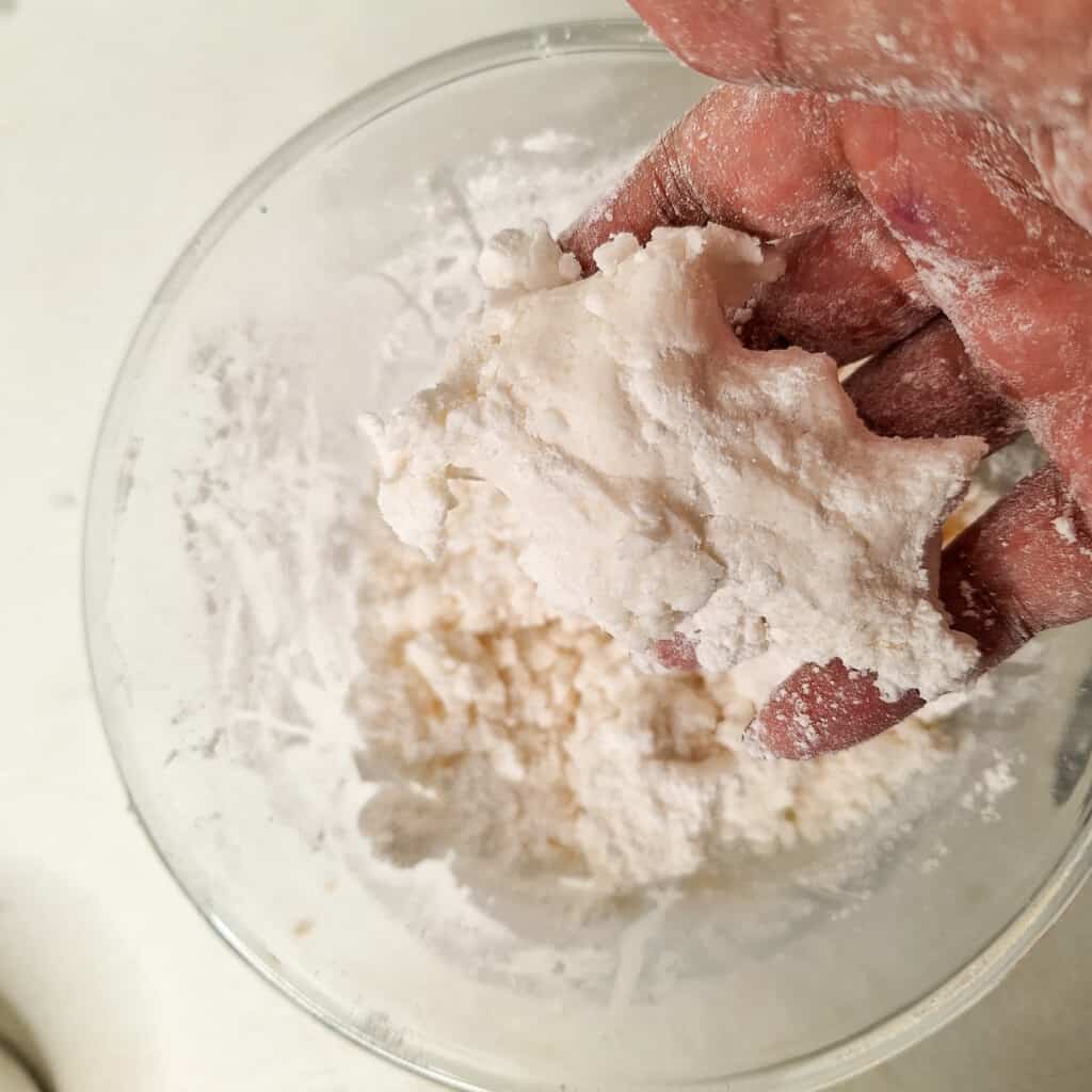 Hand squeezing some hydrated rice flour